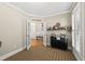Bonus room featuring a beverage bar, unique cabinets, and a doorway leading to a bench at 204 Edgepine Dr, Holly Springs, NC 27540