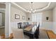Elegant dining room with wainscoting, stylish light fixture and a large window with plantation shutters at 204 Edgepine Dr, Holly Springs, NC 27540