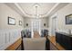 Spacious dining room with a long dark wood table, light-colored walls, and modern light fixture at 204 Edgepine Dr, Holly Springs, NC 27540