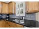 Modern kitchen with stainless steel sink, granite counters, tiled backsplash, and ample cabinet space at 204 Edgepine Dr, Holly Springs, NC 27540
