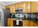 Stylish kitchen featuring stainless steel appliances, granite countertops, and wood cabinetry at 204 Edgepine Dr, Holly Springs, NC 27540