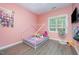 Bedroom showcasing a pink wall, ceiling fan, and hardwood flooring at 25 Silver Pl # Apt B, Angier, NC 27501
