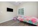 Bedroom has hardwood flooring, a TV on the wall, and a bright window at 25 Silver Pl # Apt B, Angier, NC 27501