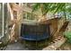 Backyard features a trampoline with exterior brick staircases, and retaining walls at 2602 Vintage Hill Ct, Durham, NC 27712