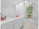 Bright, clean bathroom with white cabinets, tile floors, and a large mirror at 2602 Vintage Hill Ct, Durham, NC 27712