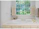 The bathroom features a soaking tub under a large window overlooking lush greenery at 2602 Vintage Hill Ct, Durham, NC 27712