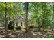 Side exterior view of home, showcasing brick facade, mature trees, and landscaped surroundings at 2602 Vintage Hill Ct, Durham, NC 27712