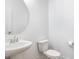 Clean, classic powder room with a pedestal sink, round mirror, and a white toilet at 27 Silver Moon Ln, Clayton, NC 27527
