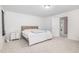 Bright bedroom featuring neutral carpet, a wooden bed frame, and a view into the attached laundry room at 27 Silver Moon Ln, Clayton, NC 27527