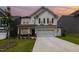 Charming two-story home with stone accents, a well-manicured lawn, and a two-car garage during sunset at 27 Silver Moon Ln, Clayton, NC 27527
