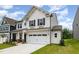 Charming two-story home with stone accents, a well-manicured lawn, and a two-car garage at 27 Silver Moon Ln, Clayton, NC 27527