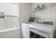 Well-lit laundry room with a front-loading washer and dryer, and wire shelving at 27 Silver Moon Ln, Clayton, NC 27527