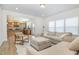 Living room with neutral furniture, large windows for natural light, and an open flow into the kitchen at 27 Silver Moon Ln, Clayton, NC 27527