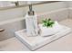Close-up shot of a marble bathroom vanity featuring a marble soap dispenser, soft towel, and bright lighting at 2716 Willow Rock Ln, Apex, NC 27523