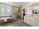 Bathroom featuring a separate tub and shower, a glass surround, a double vanity, and a walk-in closet access at 2716 Willow Rock Ln, Apex, NC 27523