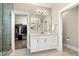 Bathroom featuring a double sink vanity with white cabinets, a walk-in closet, and a glass door shower at 2716 Willow Rock Ln, Apex, NC 27523