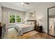 Inviting bedroom featuring hardwood floors, a comfortable bed, stylish decor, and natural light from large windows at 2716 Willow Rock Ln, Apex, NC 27523
