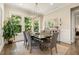 Bright dining room with natural light, modern chandelier, stylish decor, and a view of the lush green outdoors at 2716 Willow Rock Ln, Apex, NC 27523