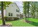 Rear exterior view of the home showcasing a patio area, well-manicured lawn, and access to the screened-in porch at 2716 Willow Rock Ln, Apex, NC 27523