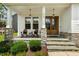 Inviting front porch with rocking chairs, decorative stone pillars, and a welcoming entrance at 2716 Willow Rock Ln, Apex, NC 27523