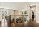 Second floor hallway overlooking the living room features hardwood floors and iron railings at 2716 Willow Rock Ln, Apex, NC 27523