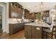 A modern kitchen with dark cabinets, white countertops, a kitchen island with barstool seating, and stainless appliances at 2716 Willow Rock Ln, Apex, NC 27523