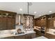 A kitchen showcasing dark wood cabinets, stainless steel appliances, a decorative light fixture, and light countertops at 2716 Willow Rock Ln, Apex, NC 27523