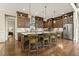 A large kitchen with dark wood cabinets, a kitchen island, three stools and stainless steel appliances at 2716 Willow Rock Ln, Apex, NC 27523