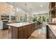 Spacious kitchen with dark wood cabinets, quartz countertops, an island, and an open-concept dining area and living room at 2716 Willow Rock Ln, Apex, NC 27523