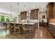 A kitchen with an island, counter seating, modern cabinets, a view to the dining area and hardwood floors at 2716 Willow Rock Ln, Apex, NC 27523