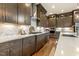 Modern kitchen featuring dark wood cabinets, stainless steel appliances, white countertops, and wood floors at 2716 Willow Rock Ln, Apex, NC 27523