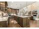 Open concept kitchen with an island, dark cabinets, stainless steel appliances, and open access to the living room at 2716 Willow Rock Ln, Apex, NC 27523