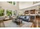 Open-concept living room features large windows, views into the kitchen, hardwood floors and comfortable seating at 2716 Willow Rock Ln, Apex, NC 27523