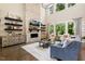 Elegant living room with stone fireplace, floating shelves, and ample natural light, perfect for relaxation and gatherings at 2716 Willow Rock Ln, Apex, NC 27523