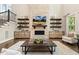 Cozy living room with stone fireplace and decorative floating shelves, ideal for a relaxing and inviting atmosphere at 2716 Willow Rock Ln, Apex, NC 27523