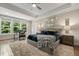Main bedroom with tray ceilings, plush rug, large windows and an accent chair at 2716 Willow Rock Ln, Apex, NC 27523