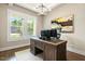 Bright office space featuring hardwood floors, modern lighting, and a wooden desk beneath an abstract art piece at 2716 Willow Rock Ln, Apex, NC 27523