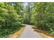 Paved walking path invites exploration through the naturally beautiful, wooded surroundings at 2716 Willow Rock Ln, Apex, NC 27523