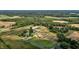 Aerial view of the farm, the pond, the fields, and the farm buildings at 2856 Gwyn Rd, Elon, NC 27244
