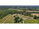 Expansive aerial view of a lush farm featuring fields, ponds, farm buildings, and a charming residence at 2856 Gwyn Rd, Elon, NC 27244
