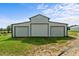 Exterior shot of a white barn with two large garage doors and a manicured lawn at 2856 Gwyn Rd, Elon, NC 27244
