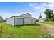 White metal barn with multiple garage doors and a green lawn and blue skies at 2856 Gwyn Rd, Elon, NC 27244