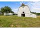 Exterior photo of a white barn with other outbuildings and a grass field in the foreground at 2856 Gwyn Rd, Elon, NC 27244