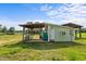 Exterior shot of a small farm building with an overhang and a lush green field at 2856 Gwyn Rd, Elon, NC 27244