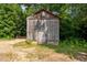 Classic weathered wooden shed, perfectly situated amid mature trees offering both utility and charm at 2856 Gwyn Rd, Elon, NC 27244