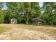 Two weathered sheds nestled among mature trees, offering rustic appeal and practical storage solutions at 2856 Gwyn Rd, Elon, NC 27244