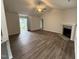 Bright living room featuring vaulted ceilings, a ceiling fan, luxury vinyl flooring, and a modern fireplace at 295 Eason Creek Way, Clayton, NC 27527