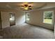 Comfortable main bedroom featuring neutral walls, carpeted floors, a ceiling fan, and two large windows at 295 Eason Creek Way, Clayton, NC 27527