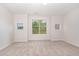Bright bedroom with neutral carpet, with large window offering outdoor views at 3036 Landing Falls Ln, Raleigh, NC 27616
