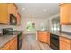 Charming kitchen with wood cabinets, black appliances, island and open to dining area at 3036 Landing Falls Ln, Raleigh, NC 27616